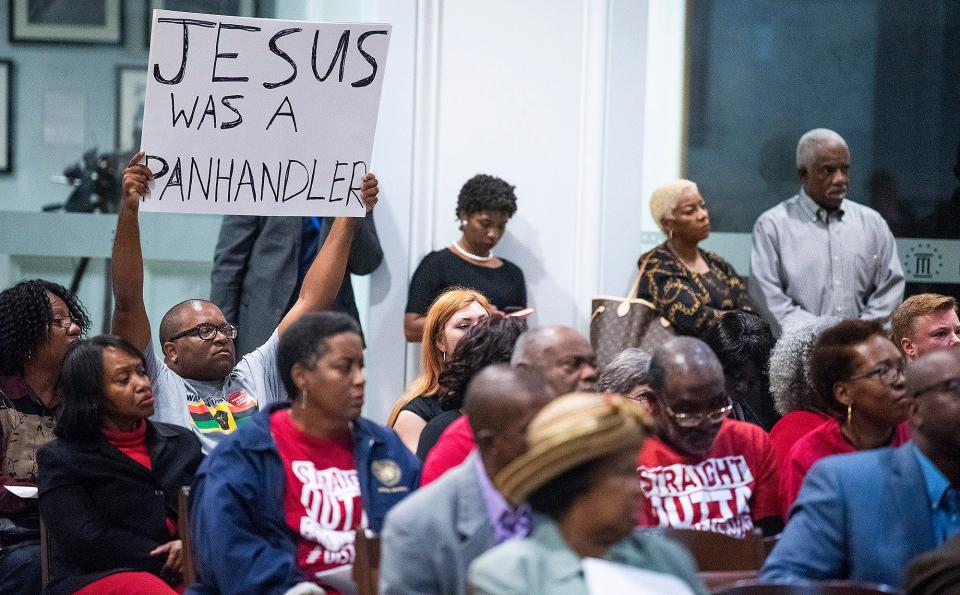 Panhandling ordinance opponent Travis Jackson holds a sign during a 2019 Montgomery City Council meeting.