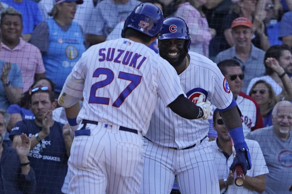 Chicago Cubs' Seiya Suzuki (27) is greeted by Franmil Reyes, right, after hitting a home run against the Cincinnati Reds during the eighth inning of a baseball game, Thursday, Sept. 8, 2022, in Chicago. (AP Photo/David Banks)