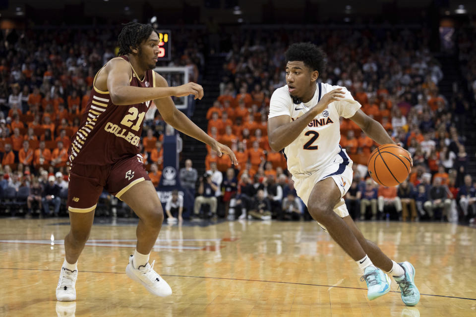 Virginia's Reece Beekman (2) drives past Boston College's Devin McGlockton (21) during the second half of an NCAA college basketball game in Charlottesville, Va., Saturday, Jan. 28, 2023. (AP Photo/Mike Kropf)