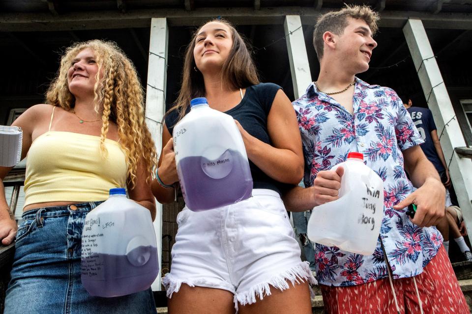 University of Delaware juniors Tiana Pritzlaff,  Ellie Crane, both 21, speak with passersby at a house party in Newark on Saturday, May 20, 2023 while holding their BORGs.