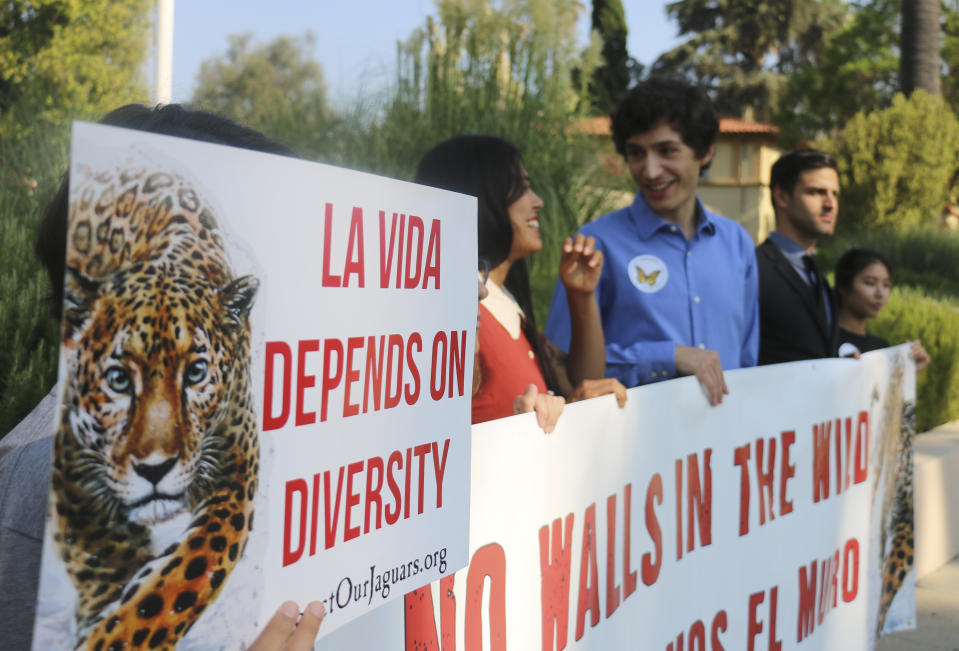 Members of the Center for Biological Diversity and other immigrant advocates protest outside 9th U.S. Circuit Court of Appeals court hearing challenging Trump's border wall Tuesday, Aug. 7, 2018, in Pasadena, Calif. A federal appeals court will hear arguments by the state of California that the Trump administration overreached by waiving environmental reviews to speed construction of the president's prized border wall with Mexico. At issue Tuesday before a three-judge panel in Pasadena, California, is a 2005 law that gave the Homeland Security secretary broad authority to waive dozens of laws including the National Environmental Policy Act and Endangered Species Act. (AP Photo/Ariel Tu)