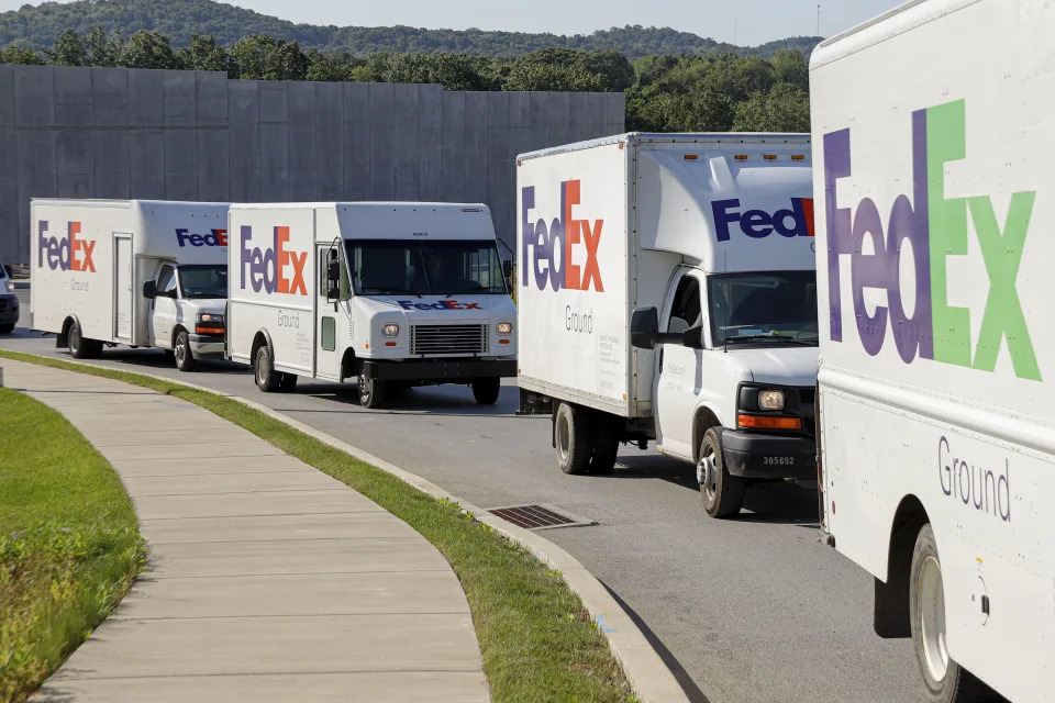 FILE - In this June 26, 2019, file photo delivery vehicles depart the FedEx Ship Center in Cranberry Township, Pa. FedEx is severing another tie with Amazon as the online powerhouse continues to strengthen its own shipping capabilities. (AP Photo/Keith Srakocic, File)