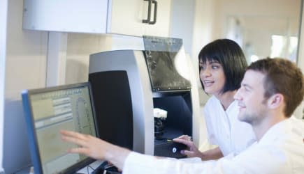 Dental technicians using computer to operate dental equipment