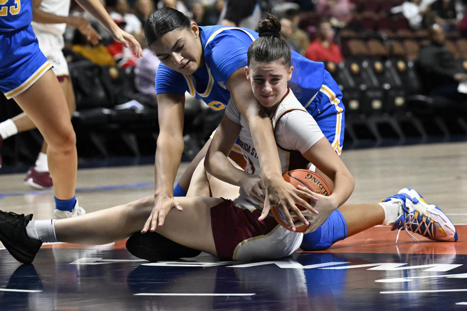 UCLA center Lauren Betts, top, pressures Florida State guard Carla Viegas in the second half of an NCAA college basketball game, Sunday, Dec. 10, 2023, in Uncasville, Conn. (AP Photo/Jessica Hill)