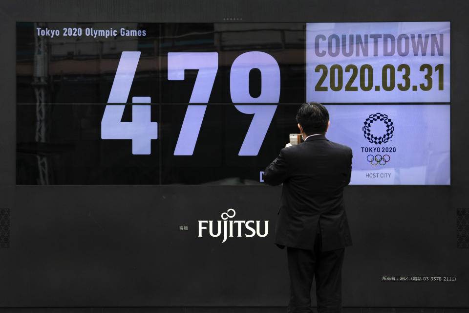 A man takes pictures of a countdown display for the Tokyo 2020 Olympics and Paralympics Tuesday, March 31, 2020, in Tokyo. The countdown clock is ticking again for the Tokyo Olympics. They will be July 23 to Aug. 8, 2021. The clock read 479 days to go. This seems light years away, but also small and insignificant compared to the worldwide fallout from the coronavirus. (AP Photo/Jae C. Hong)