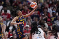 Indiana Fever guard Kelsey Mitchell (0) shoots over New York Liberty forward Jonquel Jones (35) and forward Breanna Stewart (30) in the first half of a WNBA basketball game, Thursday, May 16, 2024, in Indianapolis. (AP Photo/Michael Conroy)