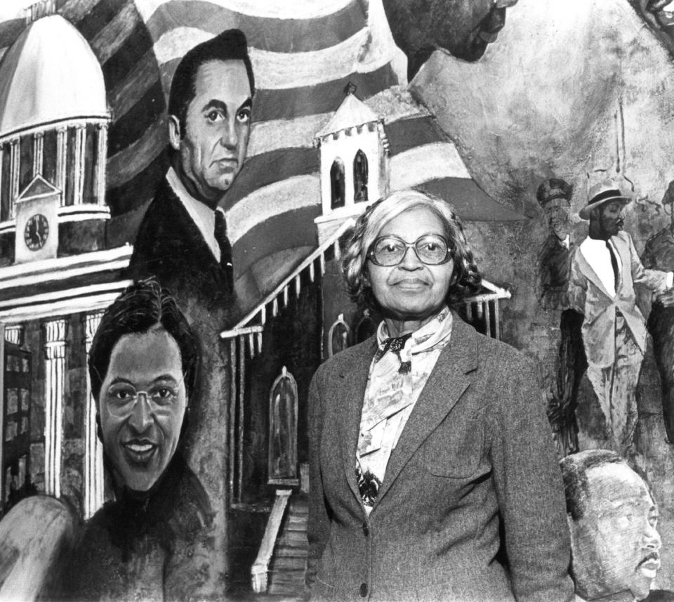 Civil rights figure Rosa Parks poses before a painted mural in the Dexter Ave. King Memorial Baptist Church in Montgomery on Dec. 2, 1985. The figures at left depict Alabama Gov. George C. Wallace and Parks during the 1955 bus boycott. The figures at right portray civil rights leader Martin Luther King Jr.
