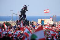 Demonstrators carry national flags during an anti-government protest in Martyrs' Square, downtown Beirut