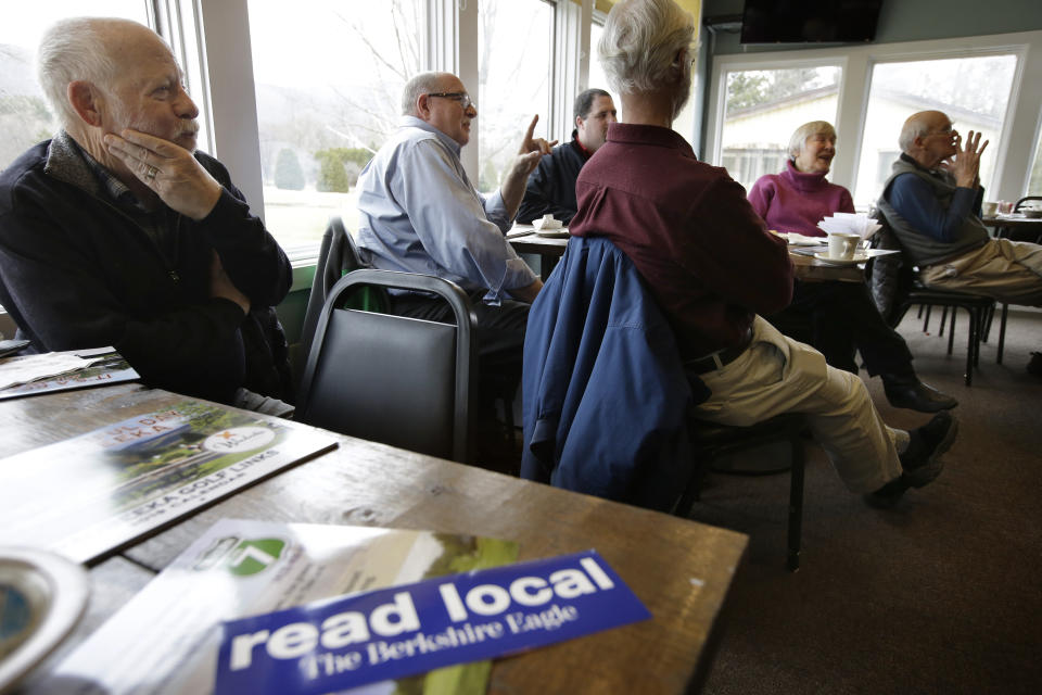 In this Wednesday, April 10, 2019 photo Lanny Lambert, of Pittsfield, Mass., left, listens listens during a "coffee with the president of The Berkshire Eagle" gathering, in Williamstown, Mass. The paper now features a new 12-page lifestyle section for Sunday editions, a reconstituted editorial board, a new monthly magazine, and the newspaper print edition is wider. That level of expansion is stunning in an era where U.S. newspaper newsroom employment has shrunk by nearly half over the past 15 years. (AP Photo/Steven Senne)