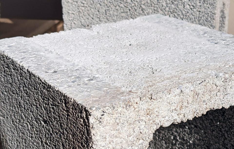 A finished concrete block using CRDC's recycled plastic material. The block has been cut away to see a cross-section. The block weighs a quarter less then a traditional block, making it less expensive and more efficient to ship and has better insulation values.