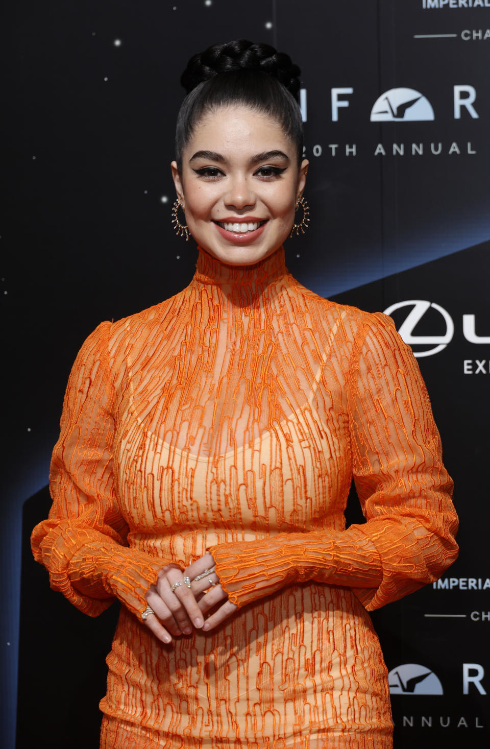 Close-up of Auli'i on the red carpet in a high-neck, long-sleeved outfit