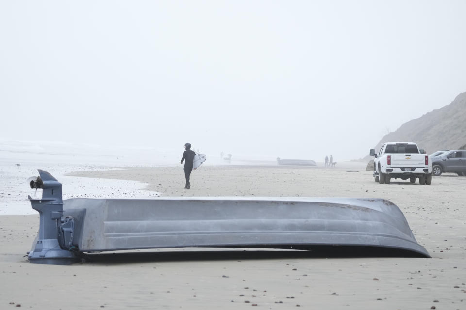 A boat sits overturned on Blacks Beach, Sunday, March 12, 2023, in San Diego. (AP Photo/Gregory Bull)