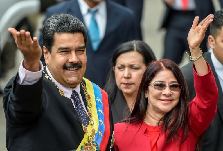 Venezuelan President Nicolas Maduro (L) and his wife, Cilia Flores wave to supporters in Caracas on January 15, 2017