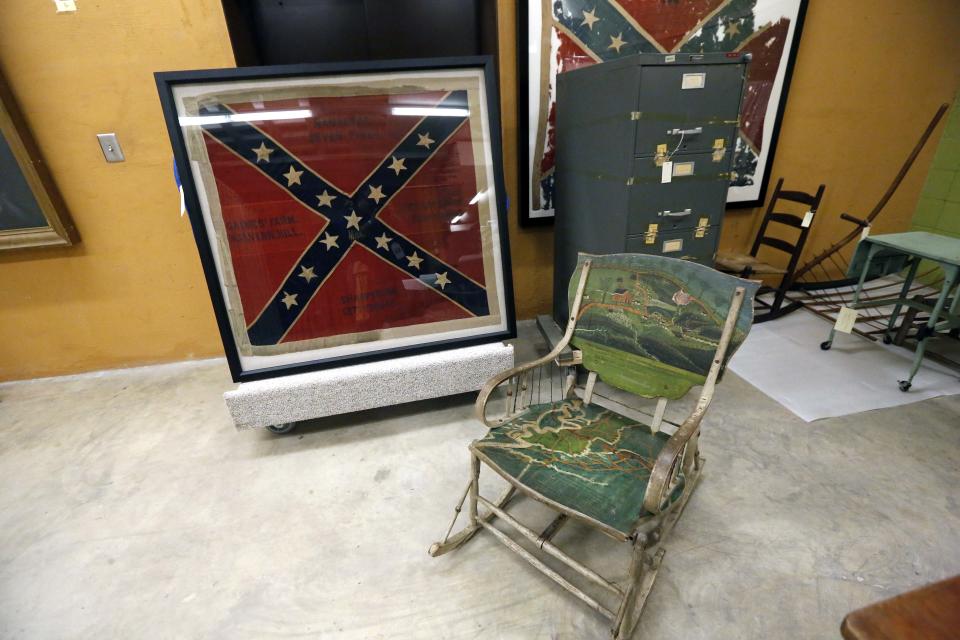 In this Oct. 11, 2013 photograph, a hand painted Civil War era double rocker, a Confederate regiment battle flag and a one-time sealed Sovereignty Commission file cabinet will eventually be displayed in either a Mississippi history museum or a civil rights museum in Jackson, Miss. Officials say they did not set out to have separate-but-equal museums for the documentation of the state's history, but it could end up that way. Groundbreaking is set for Oct. 24 for the Mississippi History Museum and the Mississippi Civil Rights Museum, side-by-side buildings, that when opened in 2017, may together tell the state's complex history. The two museums will have more than 200,000 square feet combined and are to be built not far from the Capitol in Jackson. The state has committed $40 million to the museums, and Holmes said officials are trying to raise $14 million in private donations. (AP Photo/Rogelio V. Solis)