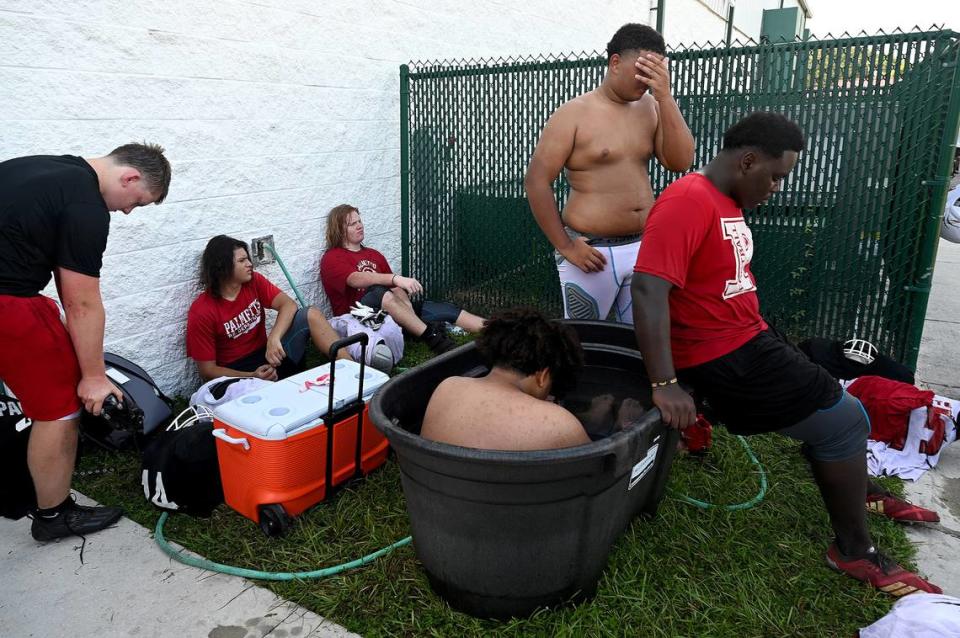 The Palmetto High football team practice at the Palmetto Charter School in the morning to try to beat the heat of the afternoons. Players find a corner of shade to cool off.