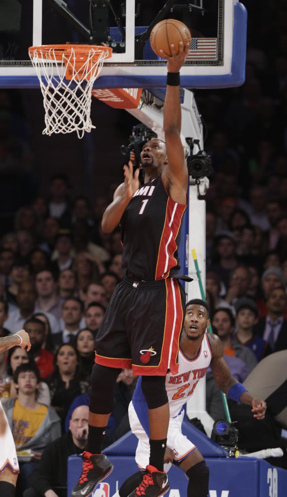 Miami Heat's Chris Bosh (1) scores in front of New York Knicks' Iman Shumpert (21) during the first half of an NBA basketball game on Thursday, Jan. 9, 2014, in New York. (AP Photo/Frank Franklin II)