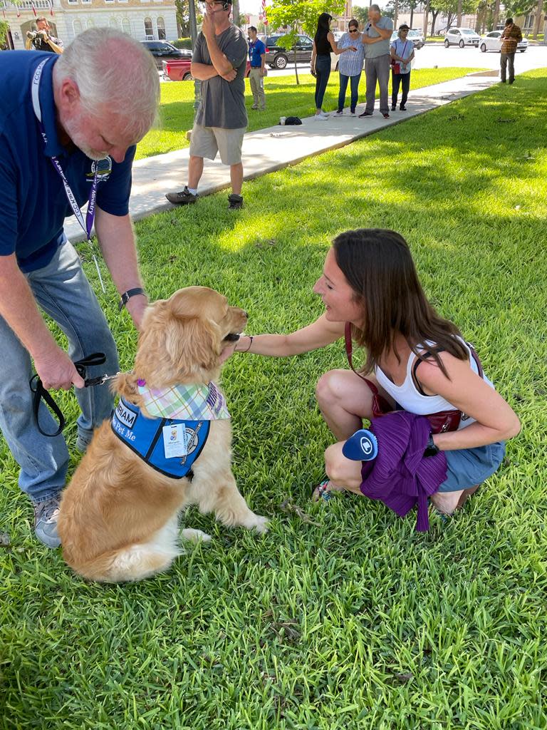 A golden retriever comforts a young girl in the town square of Uvalde, Texas, on Thursday. The town had been the site of a horrific mass shooting just days before at Robb Elementary School, where 19 children and two teachers were killed.
