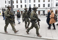 Armed police patrol outside the central station in Stockholm after a truck crashed into a department store injuring several people in a different part of Stockholm, Sweden, Friday April 7, 2017. Swedish Prime Minister Stefan Lofven says everything indicates a truck that has crashed into a major department store in downtown Stockholm is "a terror attack." (Jessica Gow/ TT News Agency via AP)