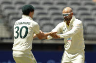 Australia's Nathan Lyon, right, celebrates with teammate Pat Cummins after taking the wicket of West Indies' Kyle Mayers on the 5th day of their cricket test in Perth, Australia, Sunday, Dec. 4, 2022. (AP Photo/Gary Day)