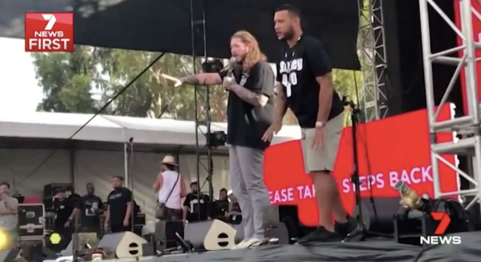 An organiser addresses the crowd while Post Malone, right, looks on. Source: 7 News