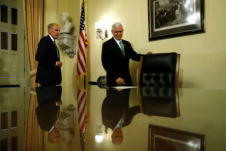 U.S. Vice President Mike Pence (R) directs Dan Coats to a desk to sign his affidavit of appointment to serve as U.S. Director of National Intelligence (DNI) for the Trump administration, after swearing him in at the U.S. Capitol in Washington, U.S. March 16, 2017. REUTERS/Jonathan Ernst