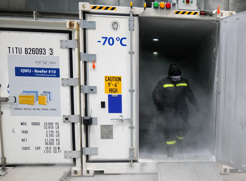 An employee of German logistic hardware producer va-Q-tec gets dry ice to fill an ultra-low temperature container to transport vaccination against the coronavirus disease (COVID-19) at the company's headquarters in Wuerzburg, Germany, November 18, 2020. REUTERS/Kai Pfaffenbach