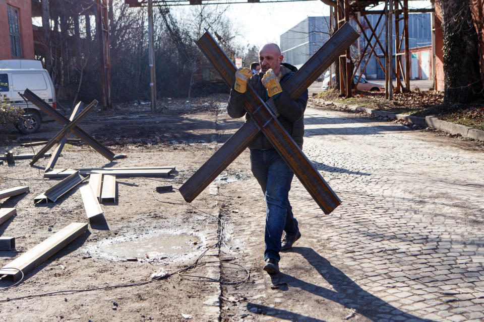 A man carries an anti-tank obstacle in Uzhhorod, in western Ukraine.