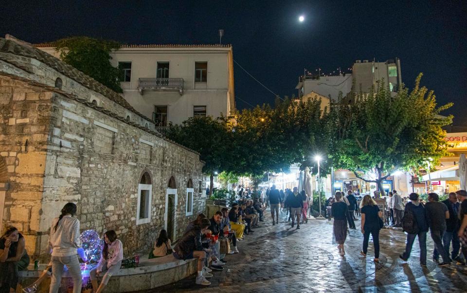 Crowds of locals and tourists enjoy a night out in Monastiraki Square, Athens