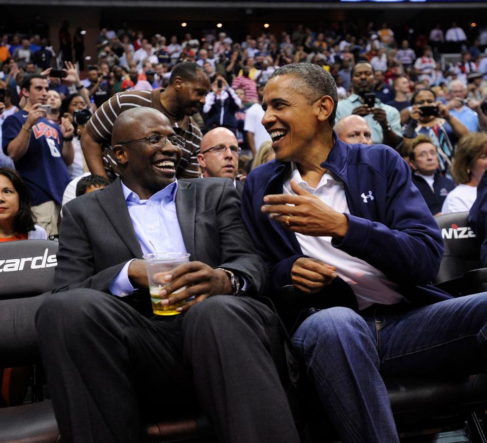 President Barack Obama shares a laugh with former White House aide Reggie Love as they watch the US Senior Men's National Team and Brazil play during a pre-Olympic exhibition basketball game at the Verizon Center on July 16, 2012 in Washington, DC.