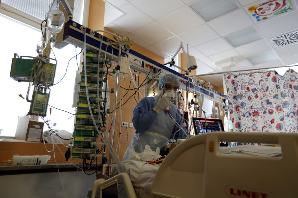 A healthcare worker attends to a COVID-19 patient in an intensive care unit (ICU) at the General University Hospital in Prague, Czech Republic, Tuesday, April 7, 2020. The new coronavirus causes mild or moderate symptoms for most people, but for some, especially older adults and people with existing health problems, it can cause more severe illness or death. (AP Photo/Petr David Josek)