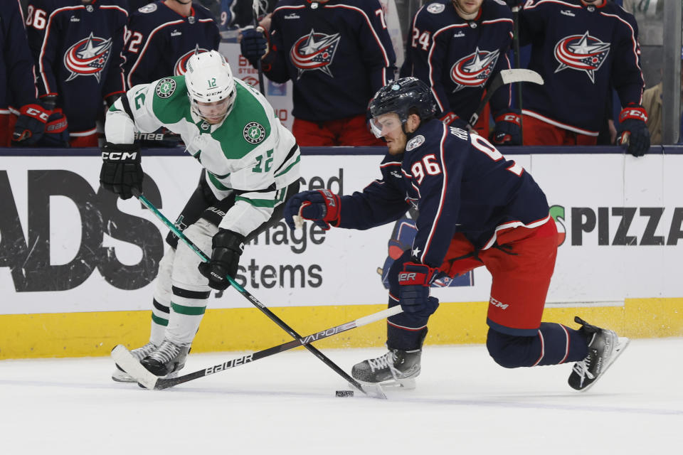 Dallas Stars' Radek Faksa, left, carries the puck across the blue line past Columbus Blue Jackets' Jack Roslovic during the third period of an NHL hockey game on Monday, Dec. 19, 2022, in Columbus, Ohio. (AP Photo/Jay LaPrete)