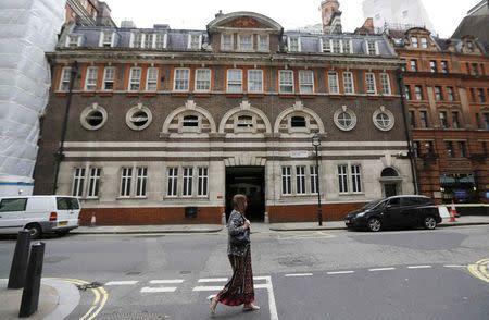 A woman walks past the site of the original Scotland Yard Police Station in London, Britain July 27, 2015. REUTERS/Suzanne Plunkett