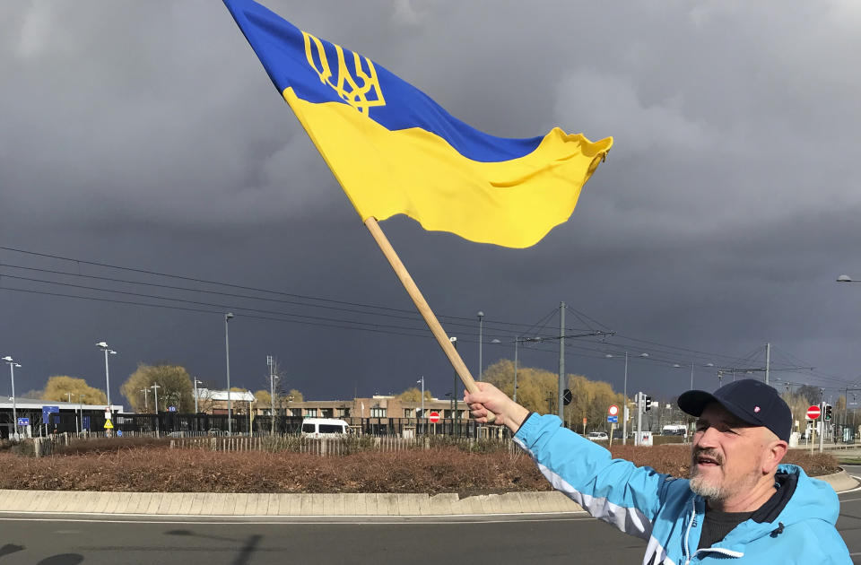 A protestor waves a Ukrainian flag as he takes part in a demonstration outside a NATO leaders virtual summit at NATO headquarters in Brussels, Friday, Feb. 25, 2022. U.S. President Joe Biden and his NATO counterparts will seek Friday to reassure member countries on the alliance's eastern flank that their security is guaranteed as Russia's large-scale invasion of Ukraine closes in on the capital Kyiv. (AP Photo/Mark Carlson)