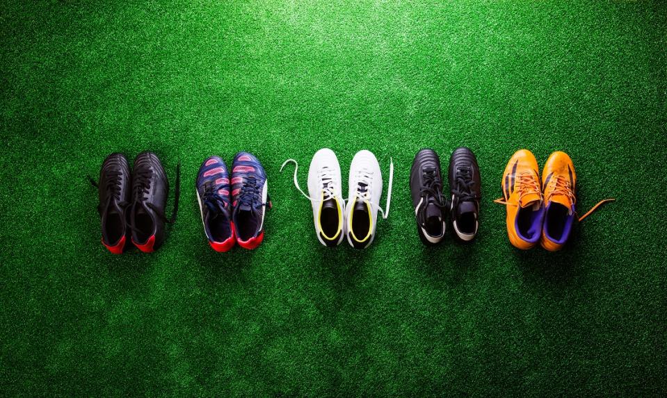 Soccer cleats lined up on a field.
