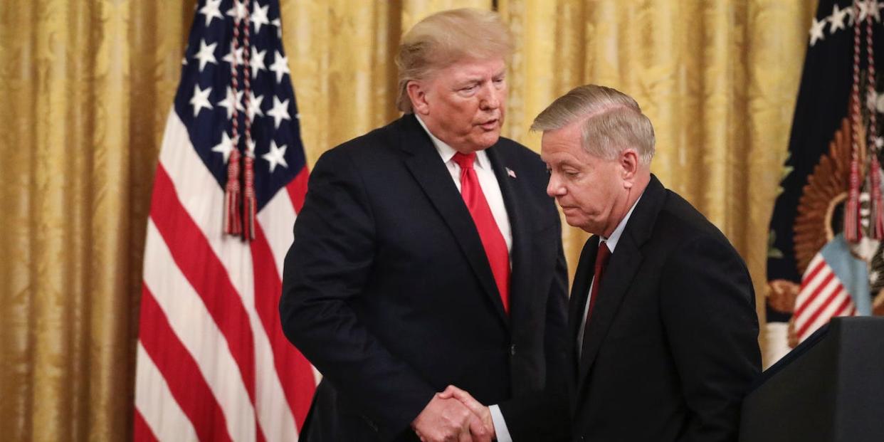 President Donald Trump shakes hands with Sen. Lindsey Graham (R-SC) during an event about judicial confirmations in the East Room of the White House on November 6, 2019