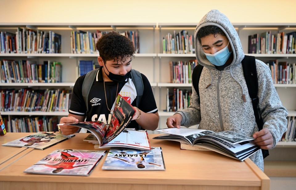 Framingham eighth graders Kaique Sousa, left, and Victor Rodrigues peruse soccer magazines in the Fuller Middle School library, Jan. 21, 2022. 