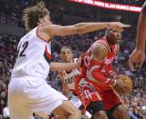 Houston Rockets' Dwight Howard (12) shoots against Portland Trail Blazers' Robin Lopez (42) and Nicolas Batum (88) during the first half of game six of an NBA basketball first-round playoff series game in Portland, Ore., Friday May 2, 2014. (AP Photo/Greg Wahl-Stephens)