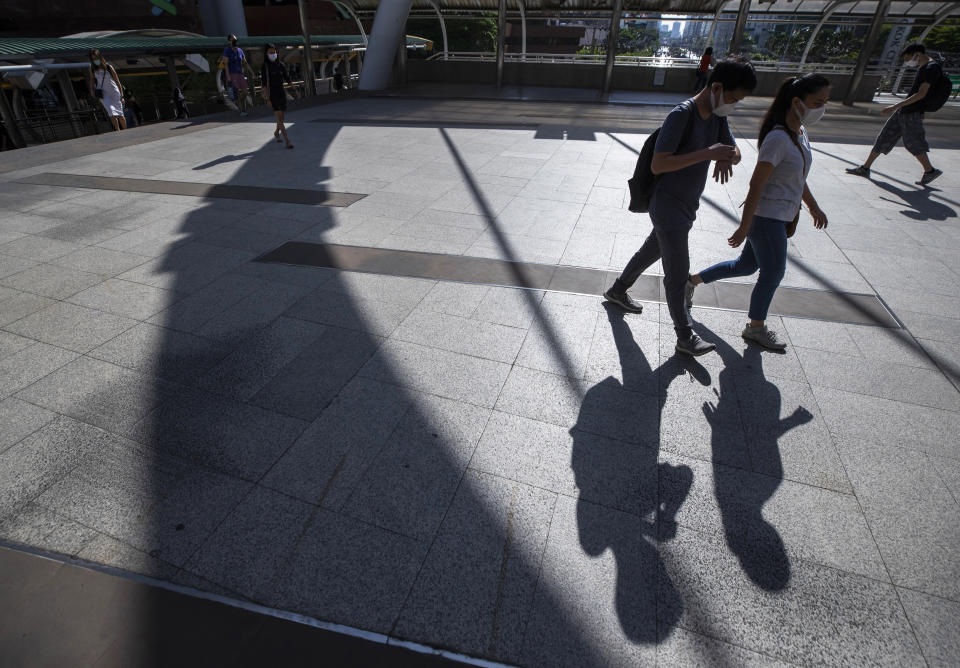 Office workers wearing face masks to help curb the spread of the coronavirus walk to work in Bangkok, Thailand, Wednesday, May 20, 2020. (AP Photo/Sakchai Lalit)