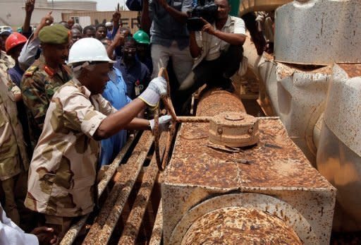 Sudanese Oil Minister Awad Ahmad al-Jaz turns the tap to start pumping oil again from the war-damaged Heglig oil facility in May 2012. Sudan and South Sudan have hammered out a deal over oil, resolving a key part of a bitter dispute that brought the rivals to the brink of all-out war earlier this year