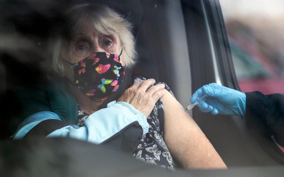 A member of the public is given a flu jab at a drive-through clinic in Scotland on Saturday - Jane Barlow/PA