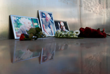Photographs of journalists, (R-L) Orhan Dzhemal, Kirill Radchenko and Alexander Rastorguyev, who were recently killed in Central African Republic by unidentified assailants, are on display outside the Central House of Journalists in Moscow, Russia August 1, 2018. REUTERS/Maxim Shemetov