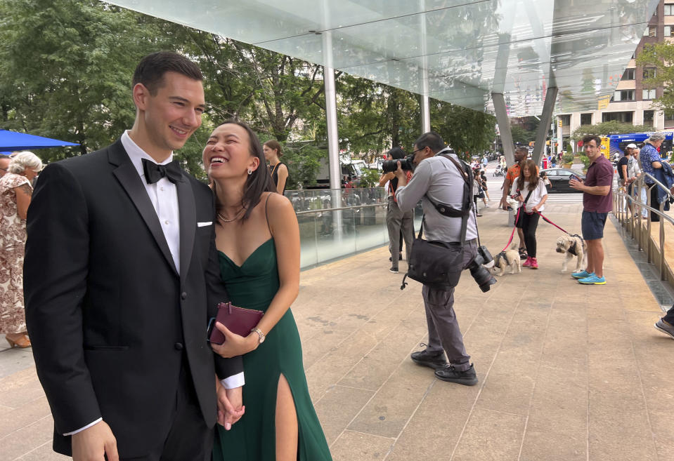 Alexander Fischer and Nina Oishi laugh and hold hands before taking part in a mass wedding at New York's Lincoln Center, Saturday, July 8, 2023. The two met while attending law school at Yale. (AP Photo/Bobby Caina Calvan)