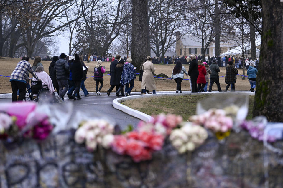 People arrive at Graceland for a memorial service for Lisa Marie Presley Sunday, Jan. 22, 2023, in Memphis, Tenn. She died Jan. 12 after being hospitalized for a medical emergency and was buried on the property next to her son Benjamin Keough, and near her father Elvis Presley and his two parents. (AP Photo/John Amis)