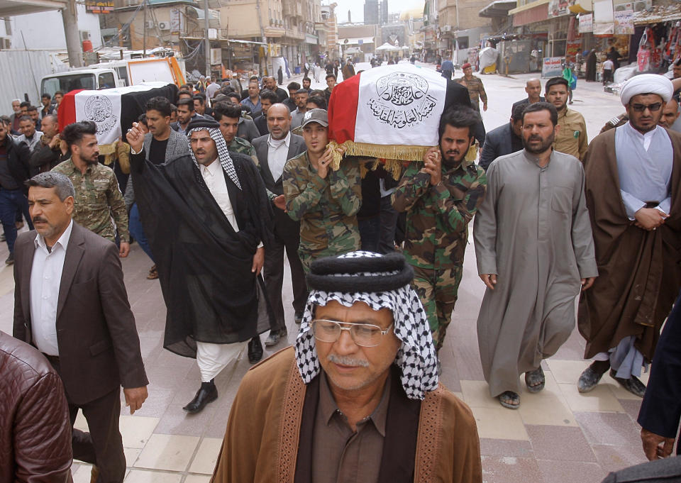 Mourners and militia fighters chant slogans against the U.S.during the funeral procession of two fighters of the Popular Mobilization Forces who were killed during the US attack against militants in Iraq, during their funeral procession at the Imam Ali shrine in Najaf, Iraq, Saturday, March 14, 2020. The U.S. launched airstrikes on Thursday in Iraq, targeting the Iranian-backed Shiite militia members believed responsible for a rocket attack that killed and wounded American and British troops at a base north of Baghdad. (AP Photo/Anmar Khalil)