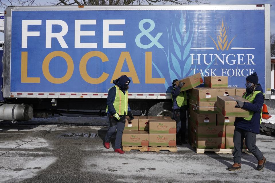 Hunger Task Force Workers distribute food Thursday, Jan. 28, 2021, at McGovern Park in Milwaukee. The Republican-controlled Wisconsin Assembly was poised Thursday to repeal Democratic Gov. Tony Evers' mask mandate, a move that would jeopardize more than $49 million in federal food assistance. (AP Photo/Morry Gash)