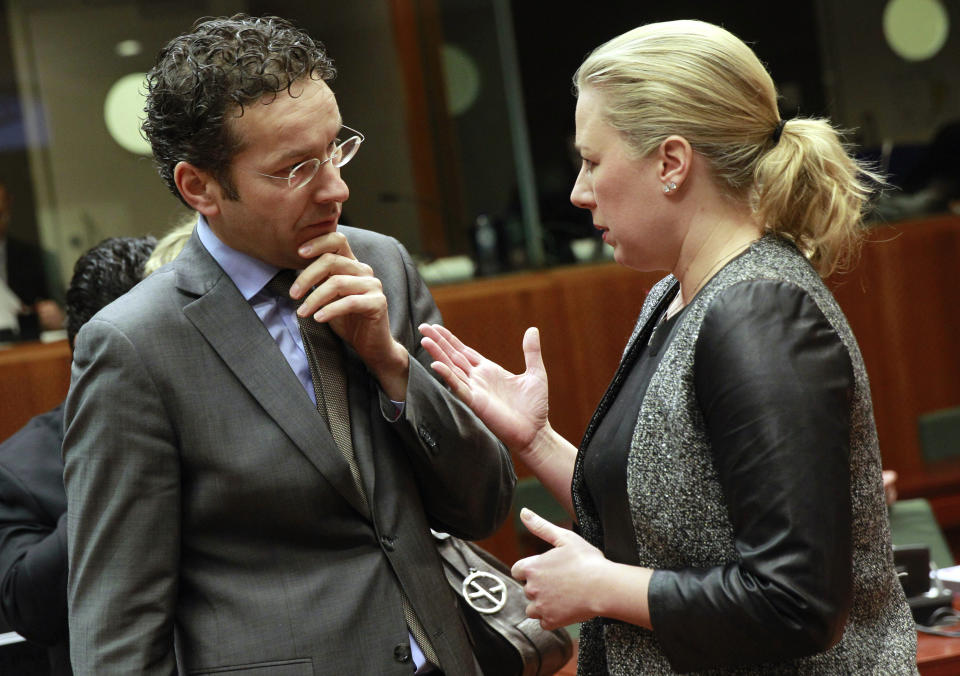 Finnish Finance Minister Jutta Urpilainen, right, talks with Dutch Finance Minister Jeroen Dijsselbloem prior to the start of the EU finance ministers meeting at the European Council building in Brussels, Tuesday, Feb. 18, 2014. (AP Photo/Yves Logghe)