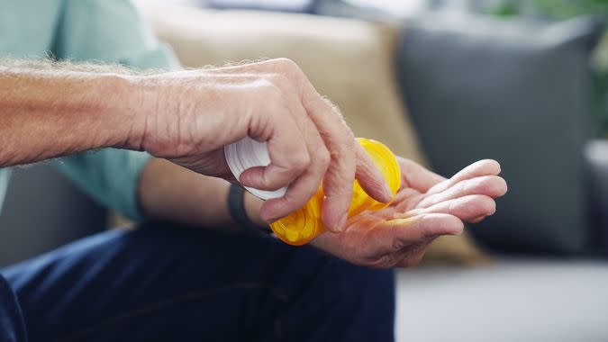 Shot of an unrecognisable senior man taking medication at home.