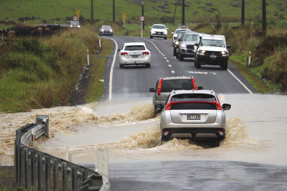 Cars move through a flooded road near Waimate, north of Auckland, New Zealand, Tuesday, May 9, 2023. Authorities in Auckland have declared a state of emergency as flooding again hits New Zealand's largest city. (Peter de Graaf/Northern Advocate via AP)