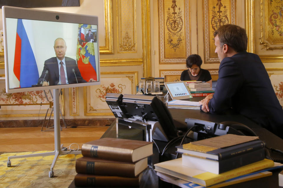 French President Emmanuel Macron talks to Russian President Vladimir Putin during a video conference Friday, June 26, 2020 at the Elysee Palace in Paris. Russian President Vladimir Putin holds video talks with French President Emmanuel Macron about the virus, Libya, Syria and relations with the U.S. under Donald Trump. (AP Photo/Michel Euler, Pool)