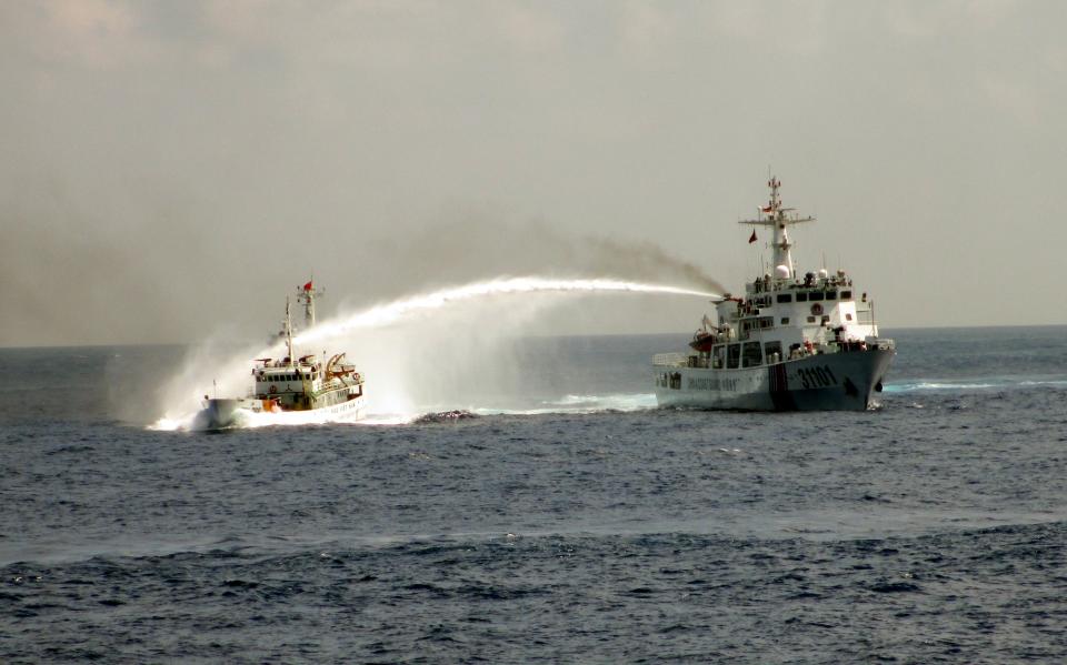 In this Sunday May 4, 2014 image made from video released by Vietnam Coast Guard, a Chinese coast guard vessel, right, fires water cannon at a Vietnamese vessel off the coast of Vietnam. China insisted Thursday, May 8, 2014 it had every right to drill for oil off Vietnam's coast and warned its neighbor to leave the area around the deep-sea rig where Chinese and Vietnamese ships are engaged in a tense standoff. With the ships jostling each other since China deployed the rig last weekend in disputed South China Sea waters, the United States warned both sides to de-escalate tensions and urged China to clarify its claims to the territory. (AP Photo/Vietnam Coast Guard)